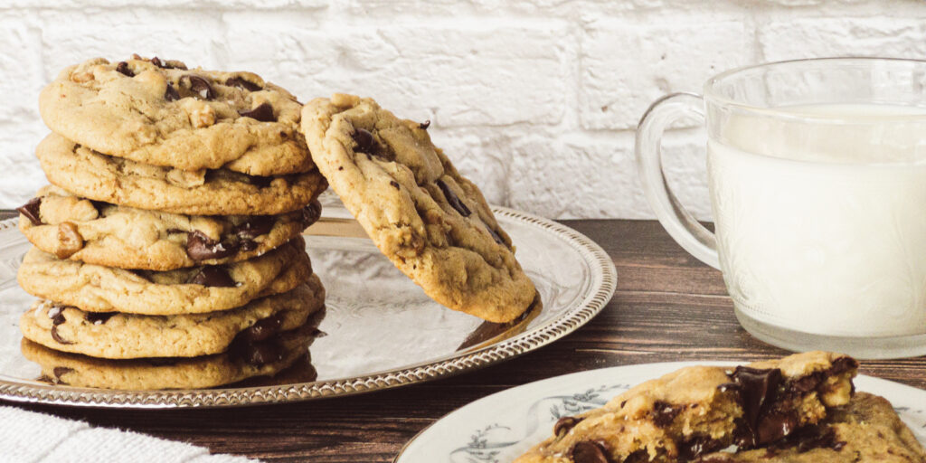 Bakery-style Chocolate Chip Cookies stacked on a plate.