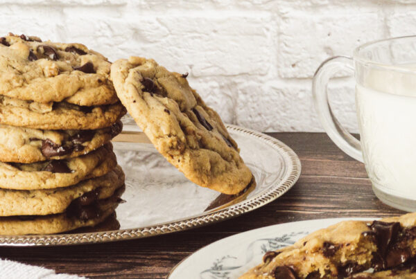 Bakery-style Chocolate Chip Cookies stacked on a plate.
