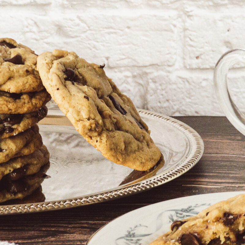 Bakery-style Chocolate Chip Cookies stacked on a plate.