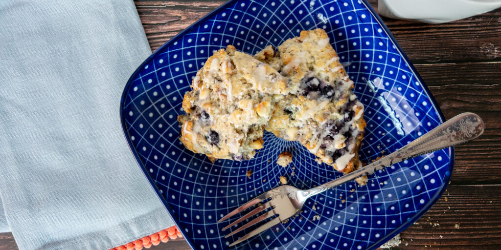 Blueberry Scones on a plate with a fork and napkin nearby.