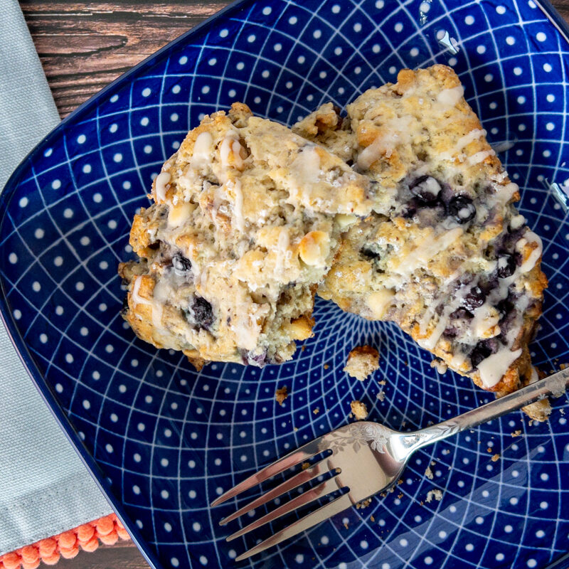 Blueberry Scones on a plate with a fork and napkin nearby.