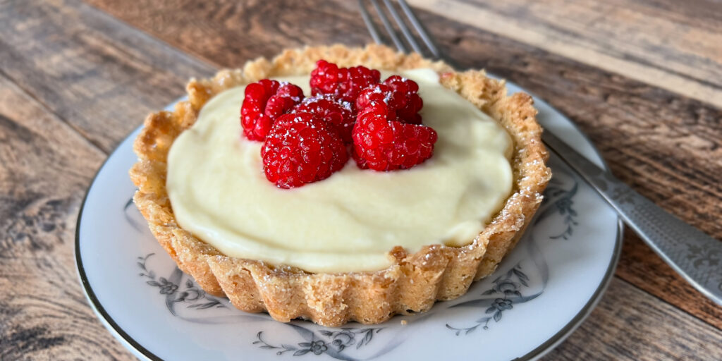 Raspberry Custard Tartlet on a plate with a fork.