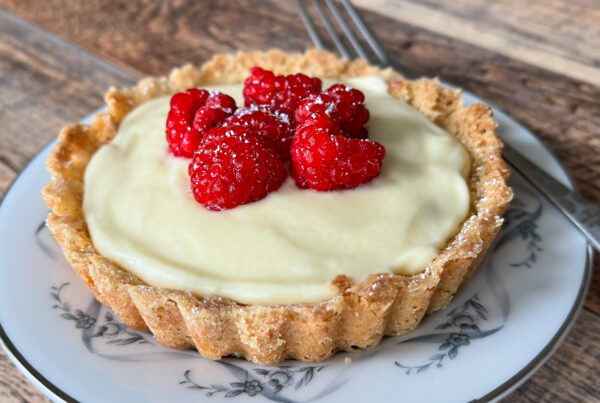 Raspberry Custard Tartlet on a plate with a fork.
