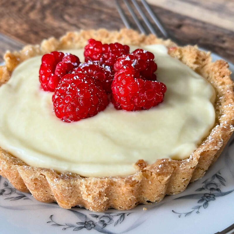 Raspberry Custard Tartlet on a plate with a fork.