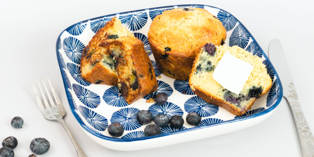 Blueberry Muffins and blueberries on a plate with a knife and fork.