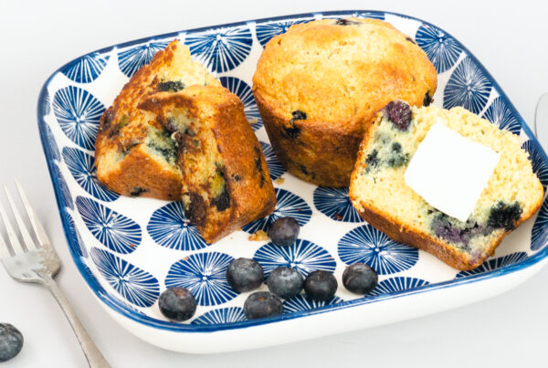 Blueberry Muffins and blueberries on a plate with a knife and fork.