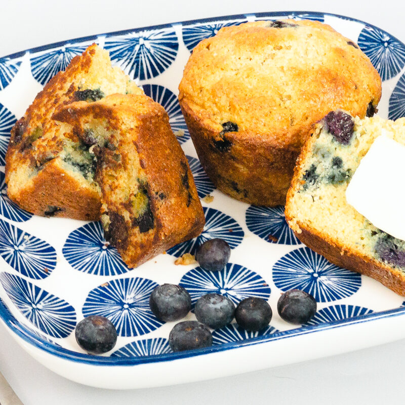 Blueberry Muffins and blueberries on a plate with a knife and fork.