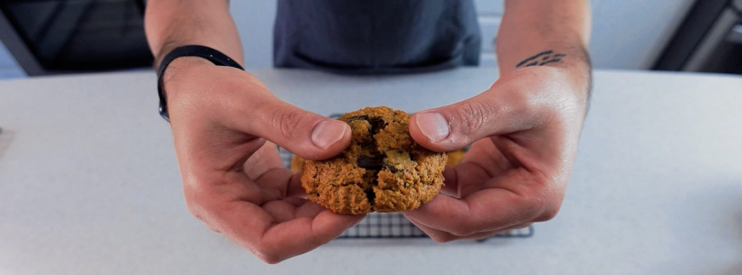 Closeup view of a Pumpkin Oatmeal Chocolate Chip Cookie being split in two.