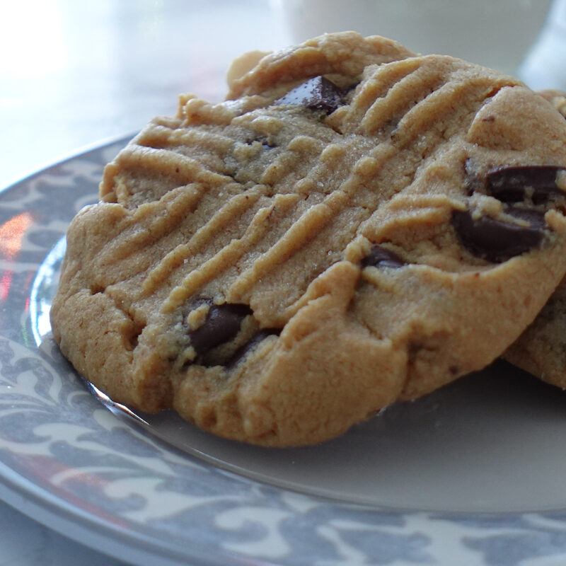 Two PB Chocolate Chip Cookies on a plate.