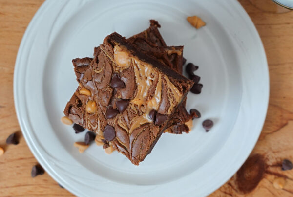 Chocolate Fudge Peanut Butter Brownies stacked on a white plate.