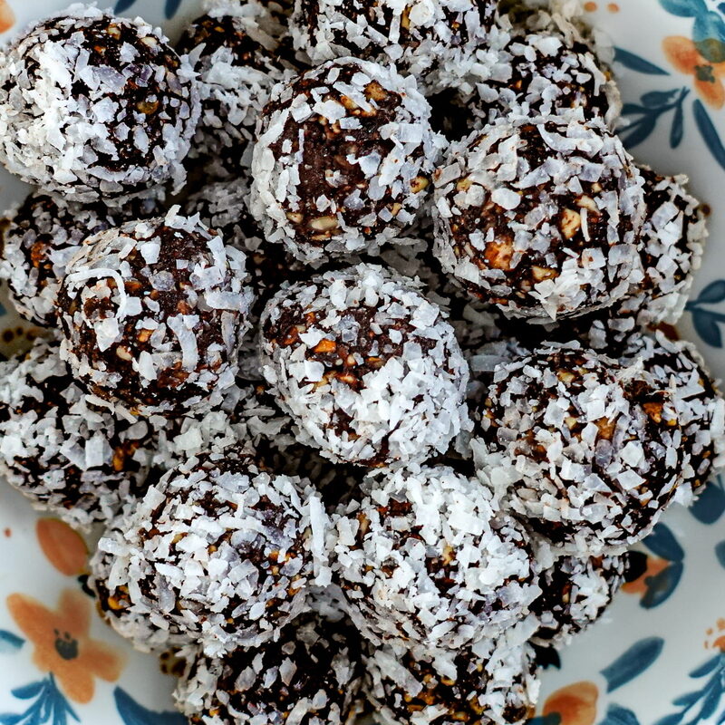 Vegan Energy Bites stacked in a bowl on a wooden table.