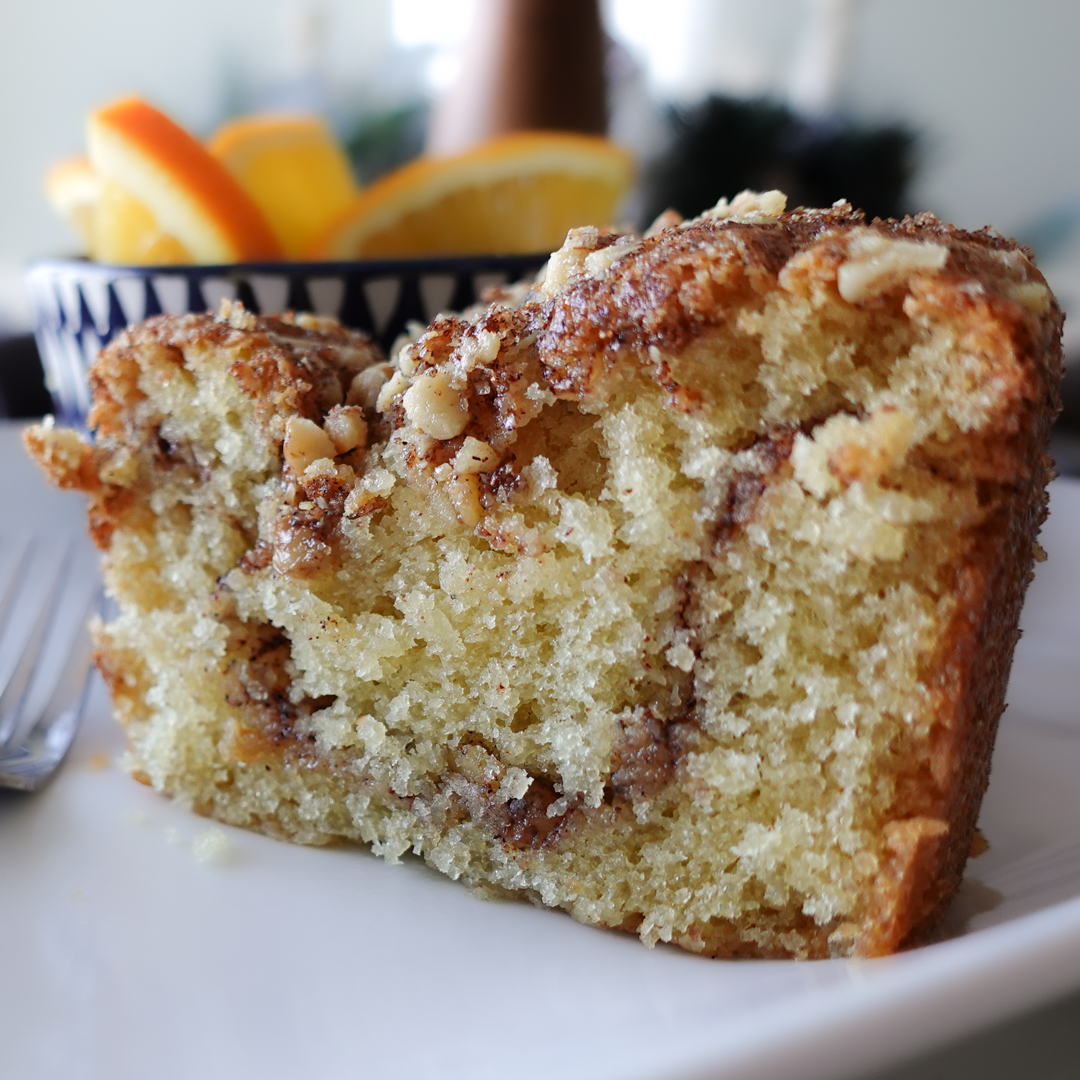 Sour Cream Coffee Cake with Crumble Topping on a white plate.