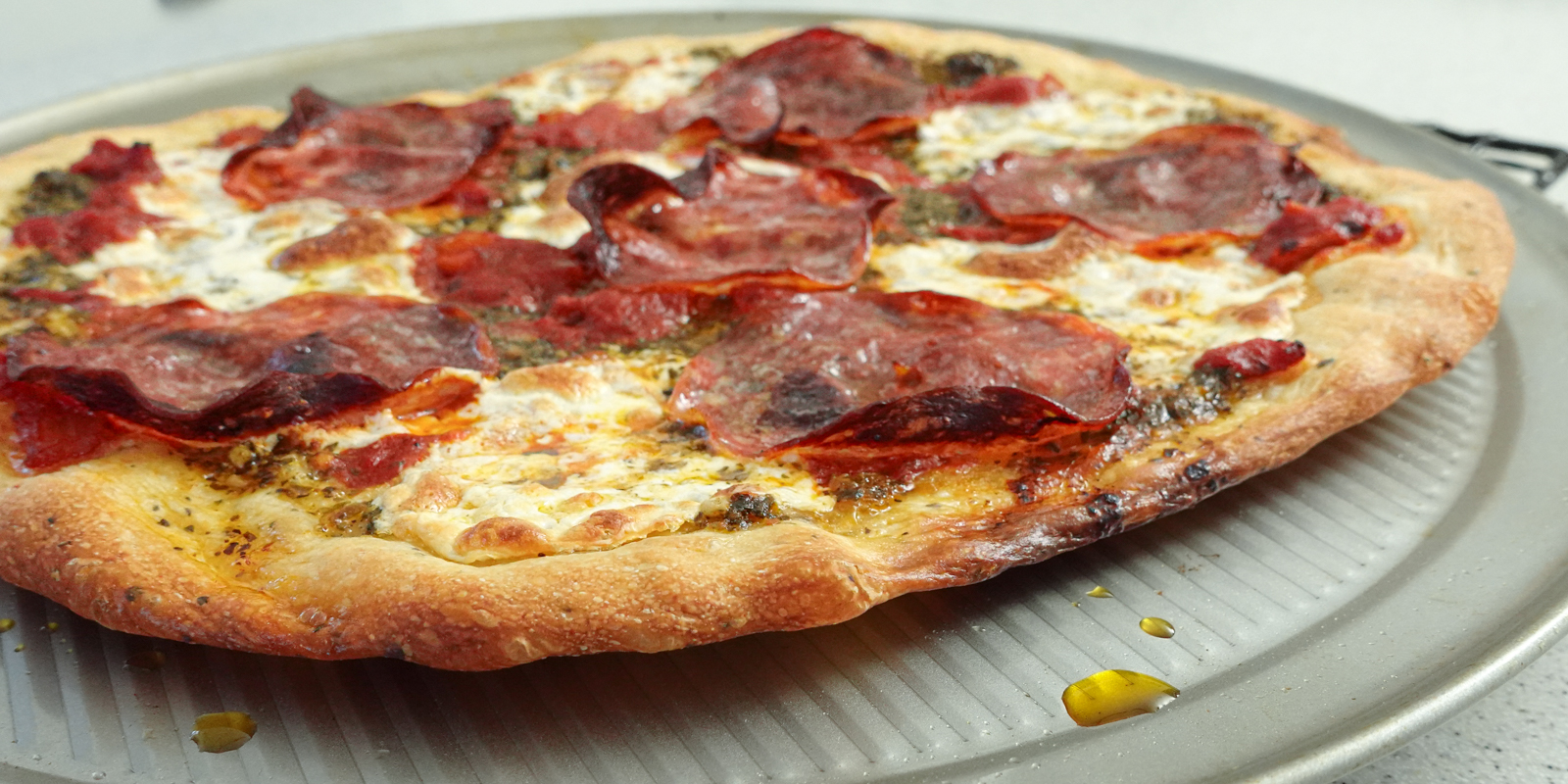 No-knead pizza fresh out of the oven on a pizza pan.