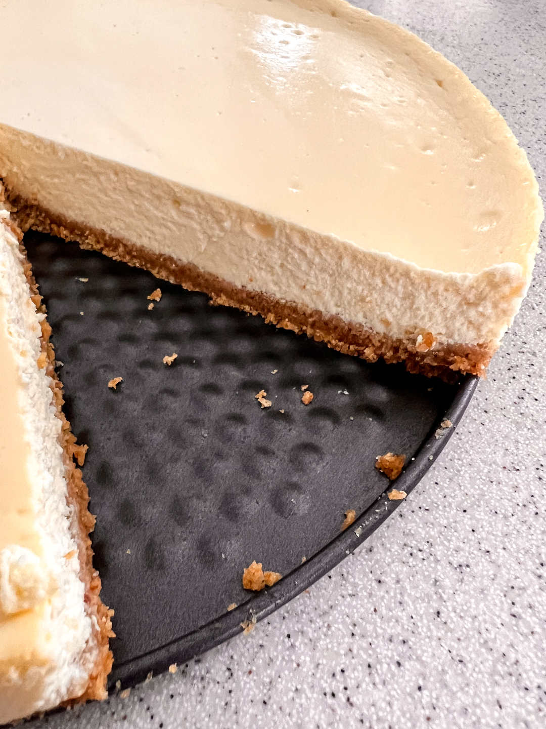 This is an image of a cheesecake on a springform pan bottom with a perfect slice cut out. This recipe will teach you how to make cheesecake.