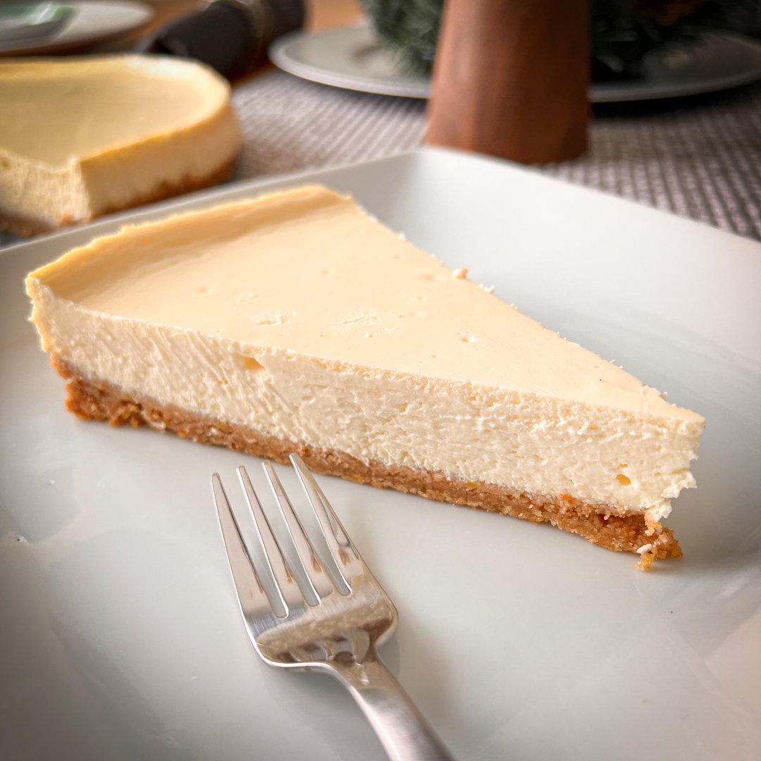 A perfect slice of cheesecake on a white plate. This recipe will help you to make cheesecake perfectly every time.