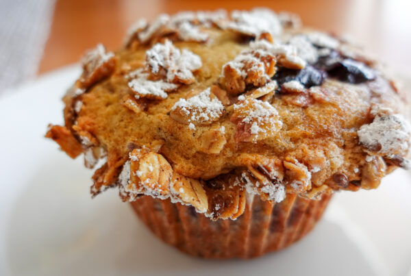 This recipe for cherry muffins creates beautiful mounds as evidenced by this image of a muffin on a white plate.