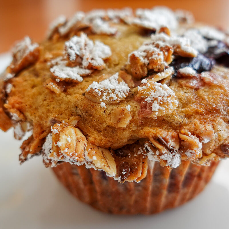 This recipe for cherry muffins creates beautiful mounds as evidenced by this image of a muffin on a white plate.