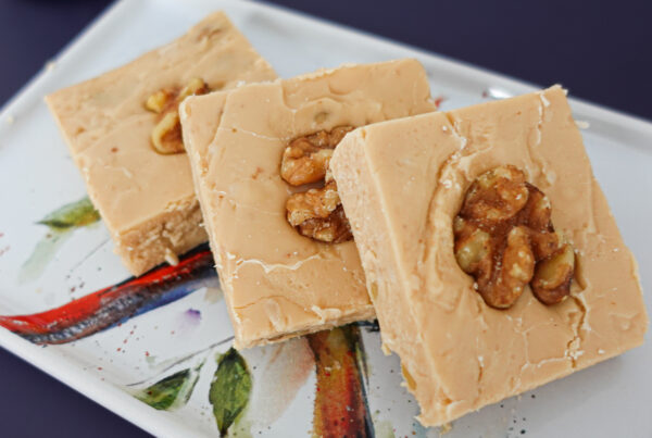 Penuche Fudge on a white plate on a blue backdrop.