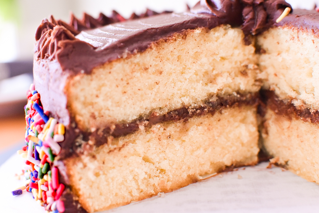 Image of the classic birthday cake with a sizable chunk sliced out of it.