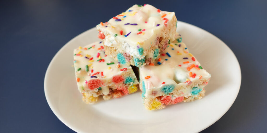 This is an image of Rice Krispie Treats Cereal Birthday Bars on a white plate.