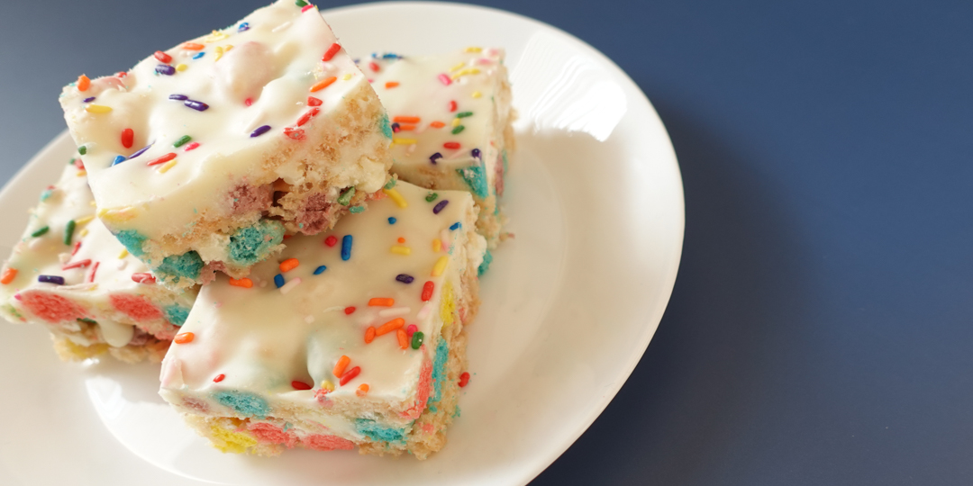 This is an aerial image of Rice Krispie Treats Cereal Birthday Bars on a white plate.