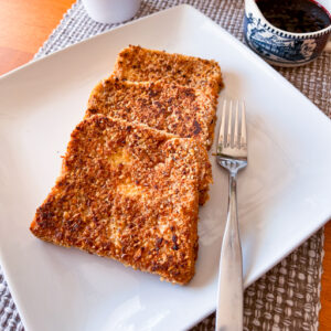 This is an up close image of three slices of granola crusted french toast.