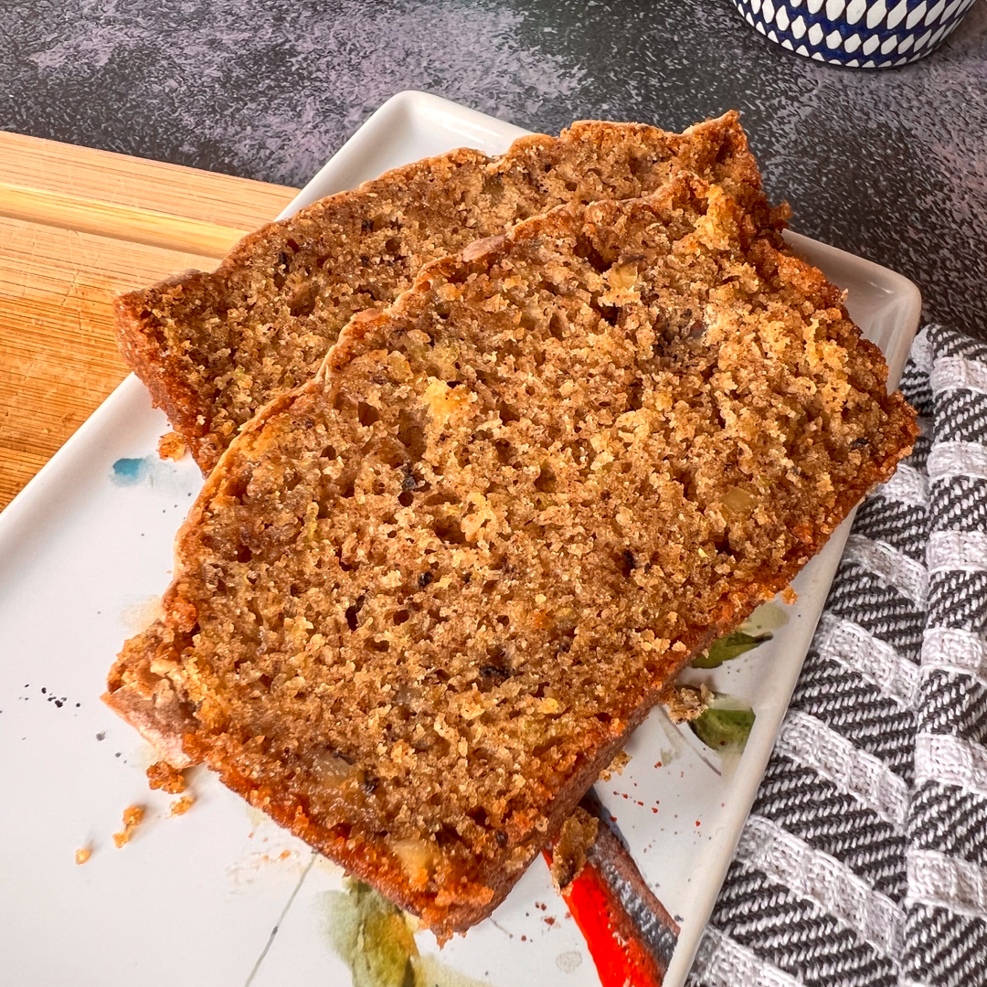 This is an image of two slices of zucchini bread on a white plate.