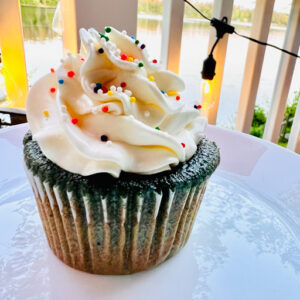 Blueberry Cupcake with Vanilla Frosting on a white plate.