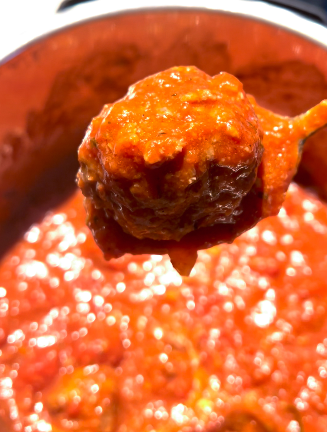 A close up image of italian meatballs in a crockpot.