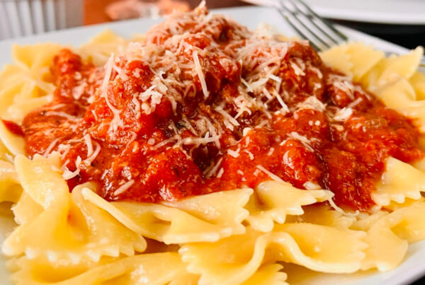 Meatballs and Pasta on a white plate with sauce.